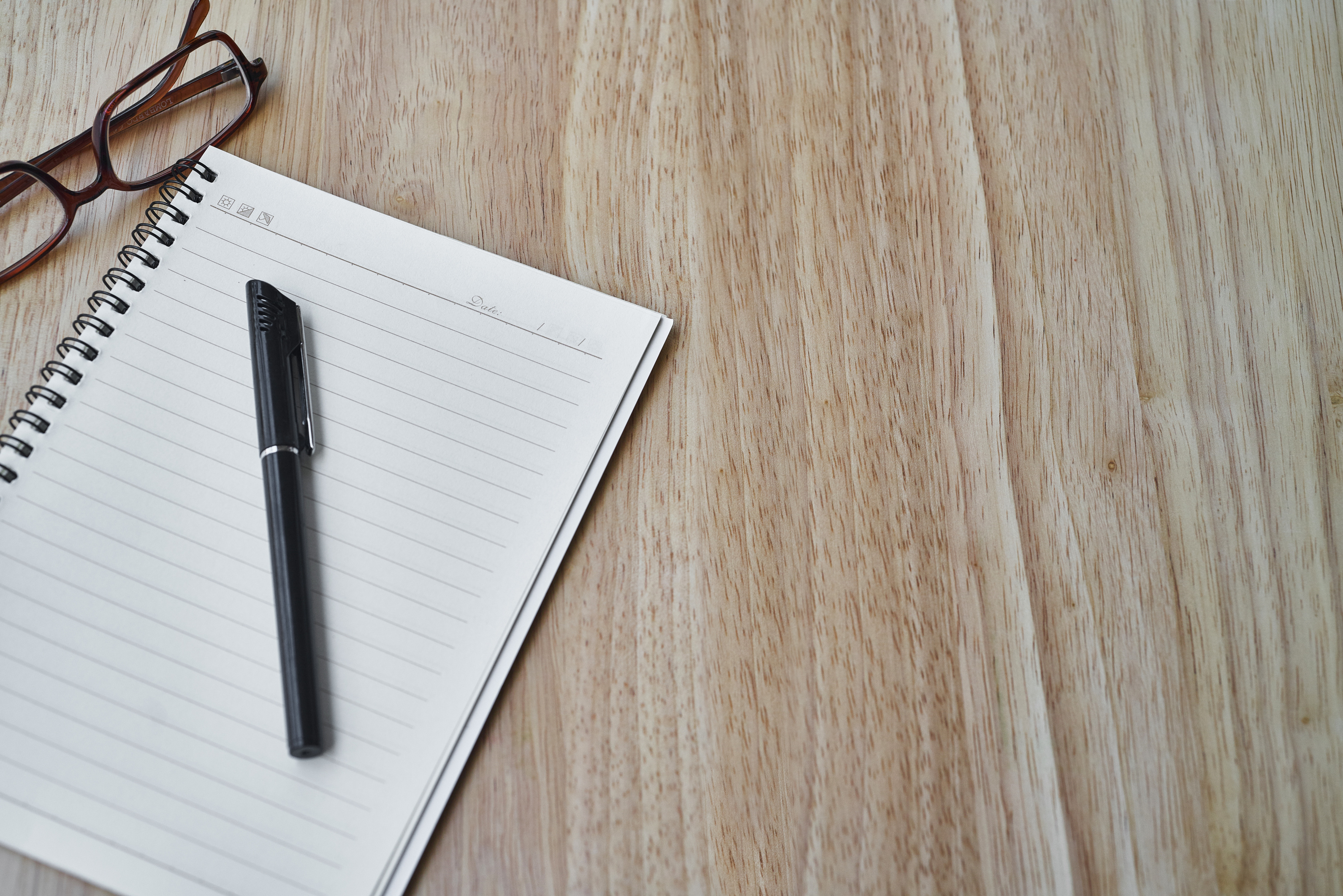 Notebook and Pen on Wooden Background